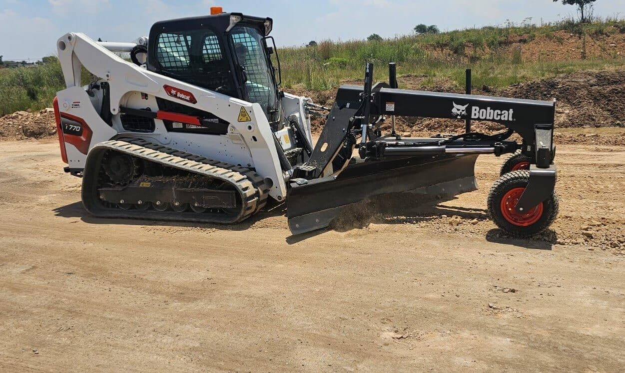 Bobcat T770 with a grading attachment shaping a haul road